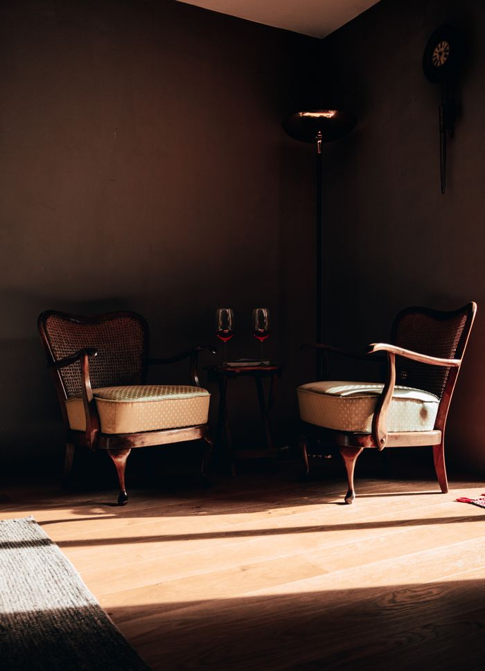 services-03 Cozy corner featuring vintage wooden chairs and ambient lighting, perfect for relaxation.
