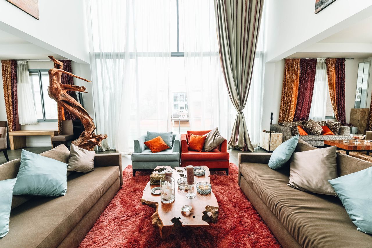 services-01 A spacious, luxurious living room with modern furnishings and natural wood decor.
